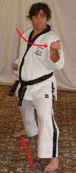 DSCF0025 4) Move right leg diagonally out, turn 90° left towards C hip-twisting into a left walking stance whilst performing middle block with left forearm