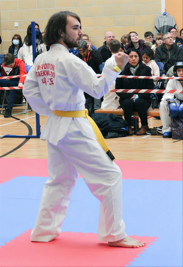 rhys-doing-pattern-unblur A student at a competition shows the white Revolution Taekwon Do Dobok.