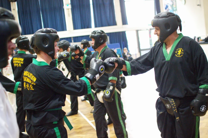 IMG_0790 Students in full protective kit touch gloves in salute while smiling